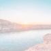 brown rocky mountain beside body of water during sunset